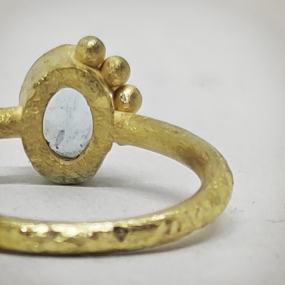 Dettaglio posteriore del castone circolare di un anello in oro grezzo
